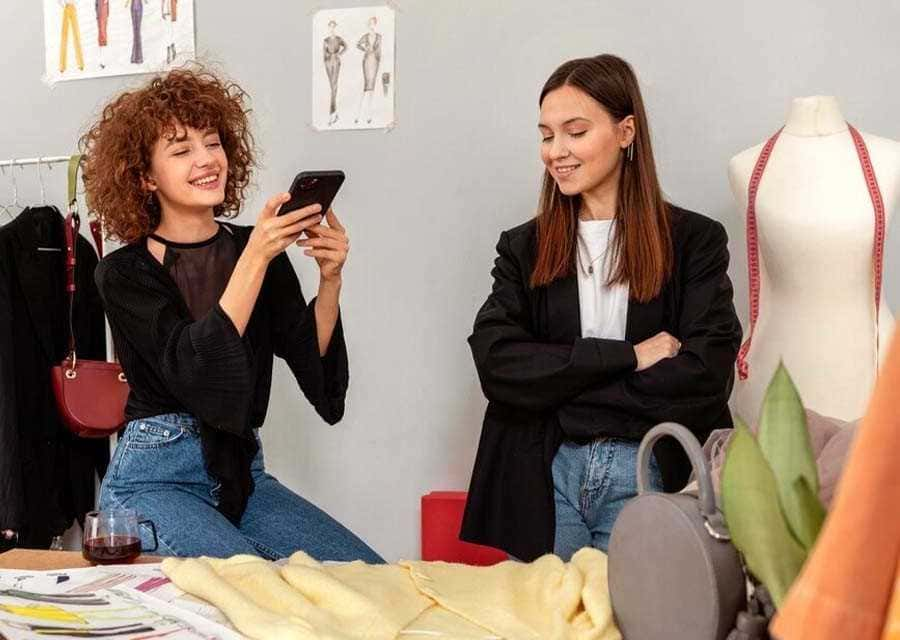 Two women sitting, absorbed in their cell phones